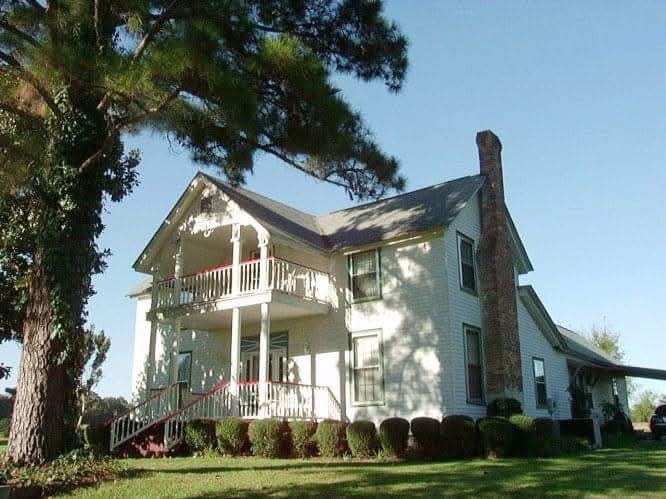 Well-kept grounds around a classic white farmhouse